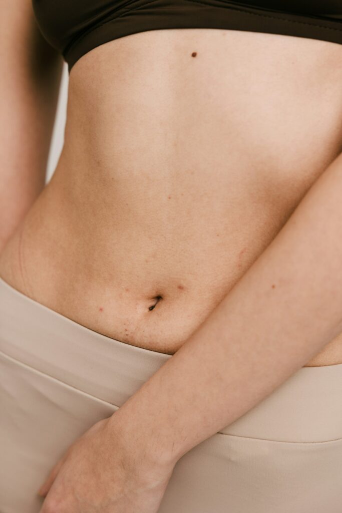 A close up photo of a woman's stomach and belly button.
